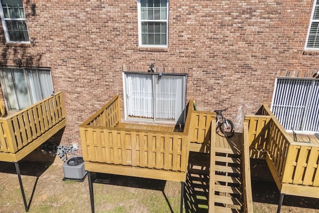 view of exterior entry with central AC unit and brick siding