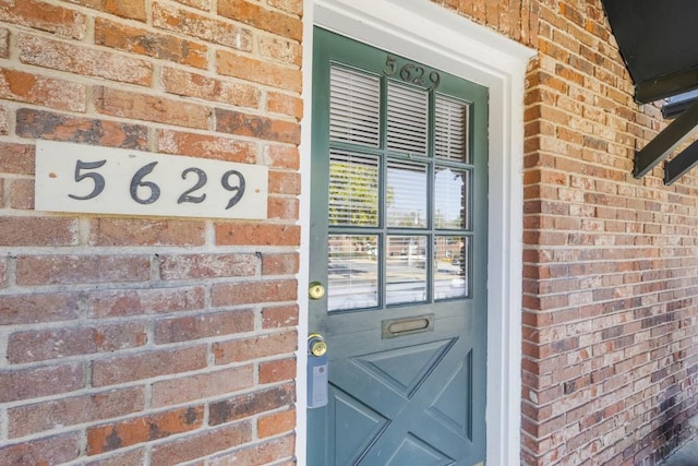 entrance to property featuring brick siding