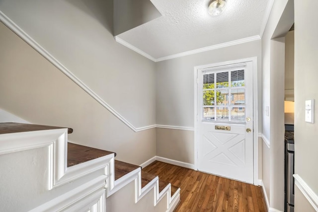 entryway featuring baseboards, ornamental molding, wood finished floors, stairs, and a textured ceiling