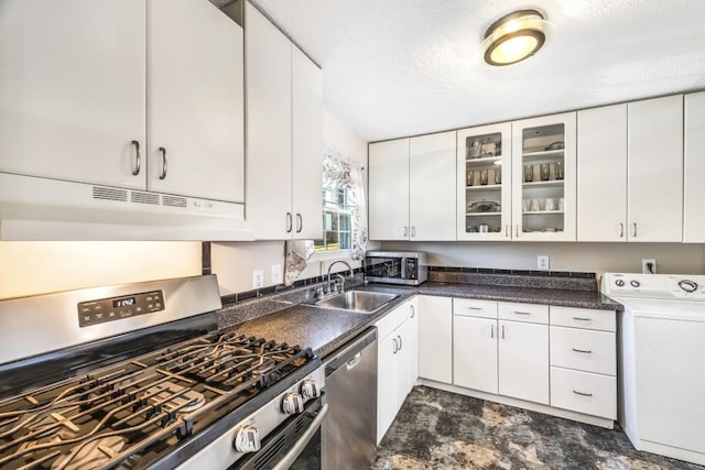 kitchen featuring appliances with stainless steel finishes, white cabinets, a sink, washer / dryer, and under cabinet range hood