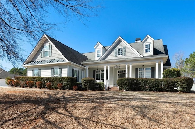 view of front facade featuring covered porch and a standing seam roof