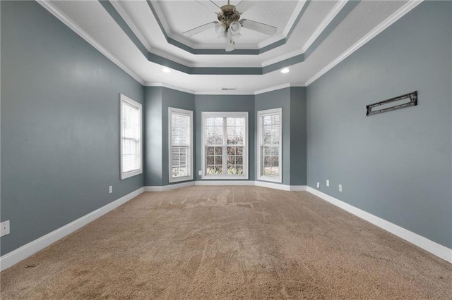 spare room with a raised ceiling, ornamental molding, light carpet, ceiling fan, and baseboards