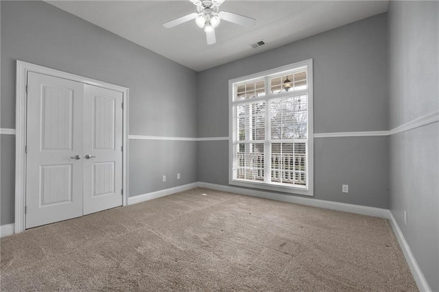 unfurnished bedroom featuring carpet floors, a closet, visible vents, and baseboards