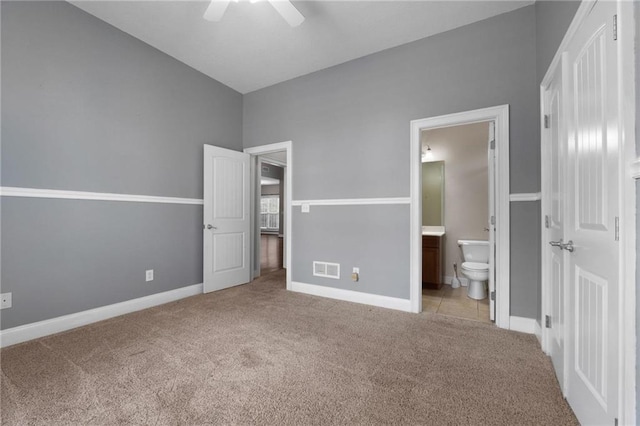 unfurnished bedroom featuring light carpet, ensuite bath, visible vents, and baseboards