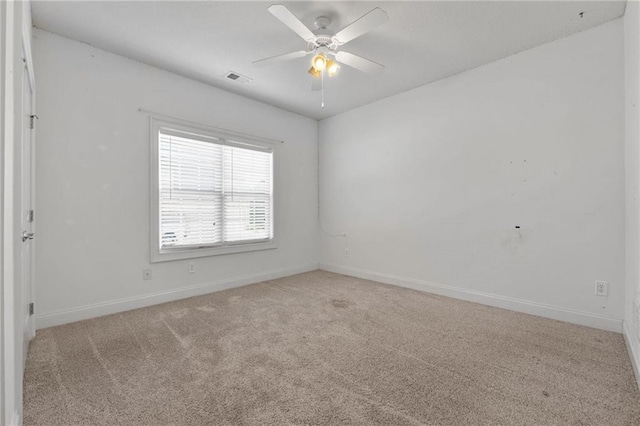 unfurnished room with light carpet, ceiling fan, visible vents, and baseboards