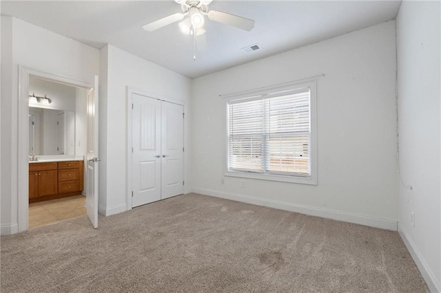 unfurnished bedroom featuring light carpet, a closet, visible vents, and baseboards