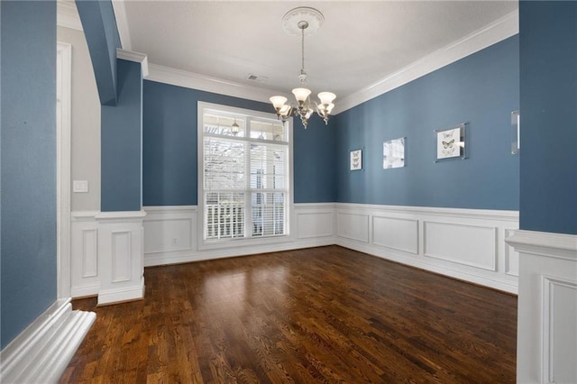 unfurnished dining area with visible vents, wainscoting, ornamental molding, dark wood-type flooring, and a notable chandelier