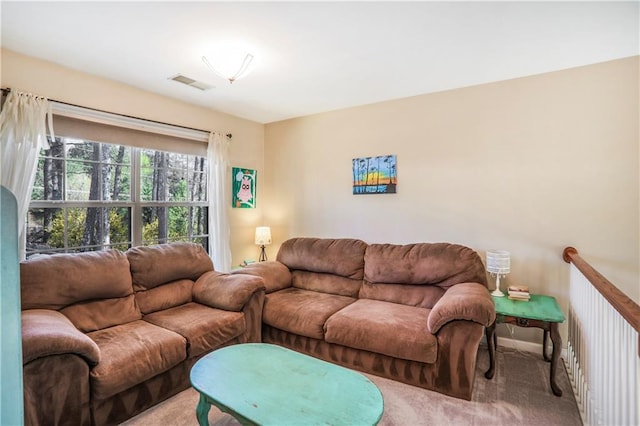 office featuring visible vents, baseboards, a ceiling fan, a wealth of natural light, and light colored carpet