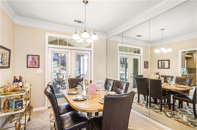dining space featuring visible vents, crown molding, an inviting chandelier, french doors, and light colored carpet