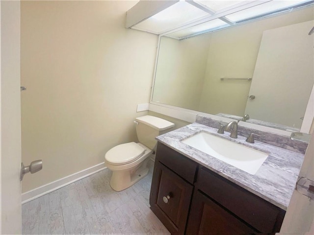 bathroom with vanity, wood-type flooring, and toilet