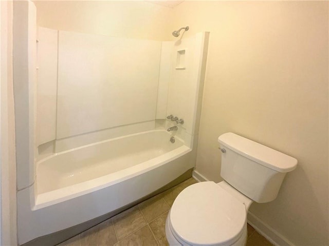 bathroom with washtub / shower combination, tile patterned floors, and toilet