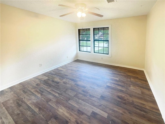 empty room with dark hardwood / wood-style flooring, a textured ceiling, and ceiling fan