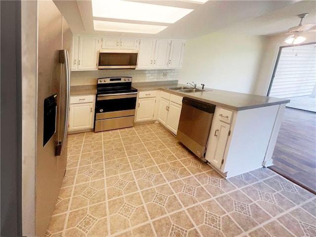 kitchen featuring white cabinetry, stainless steel appliances, and kitchen peninsula