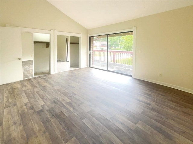 interior space featuring dark hardwood / wood-style floors, multiple closets, access to exterior, and high vaulted ceiling