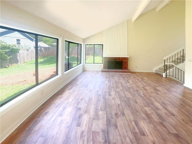 unfurnished sunroom with a fireplace and vaulted ceiling with beams