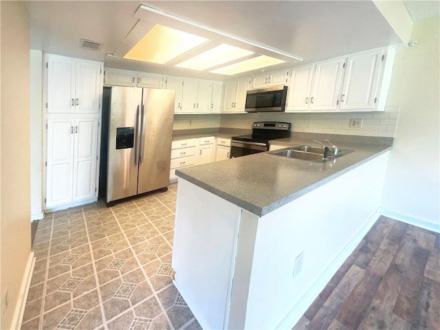 kitchen featuring white cabinetry, stainless steel appliances, kitchen peninsula, and sink