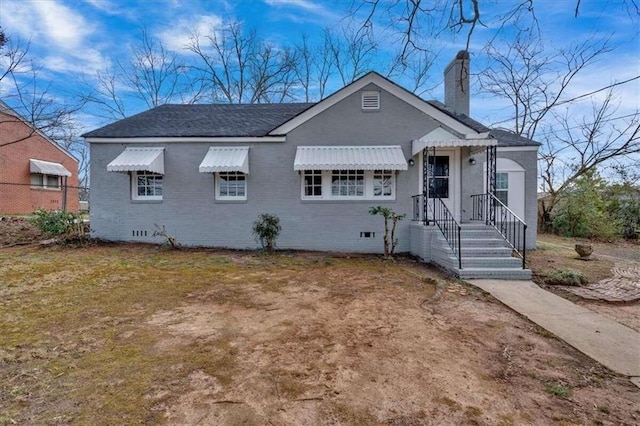 bungalow with brick siding, crawl space, and a chimney