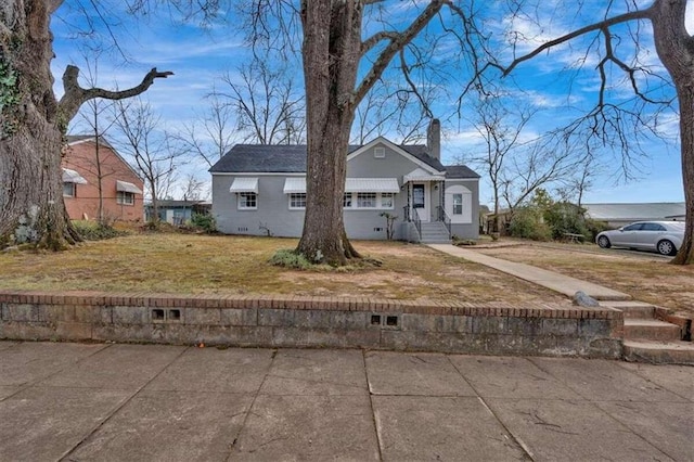 view of front of home with a chimney and a front lawn