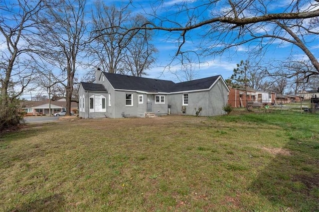 exterior space featuring entry steps, a lawn, a chimney, and fence