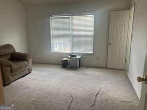 sitting room featuring light carpet