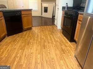 kitchen with black appliances and light hardwood / wood-style flooring