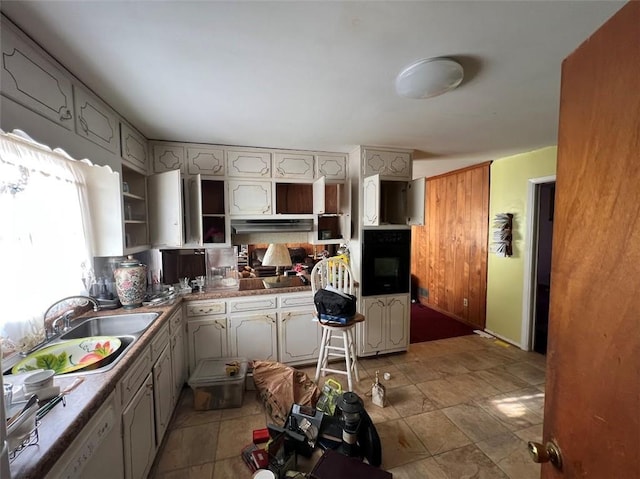 kitchen with oven, sink, washer and clothes dryer, and gray cabinetry