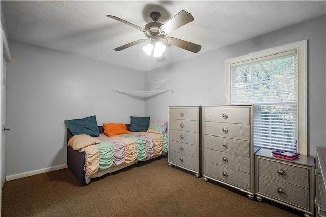 bedroom featuring dark carpet, baseboards, and ceiling fan