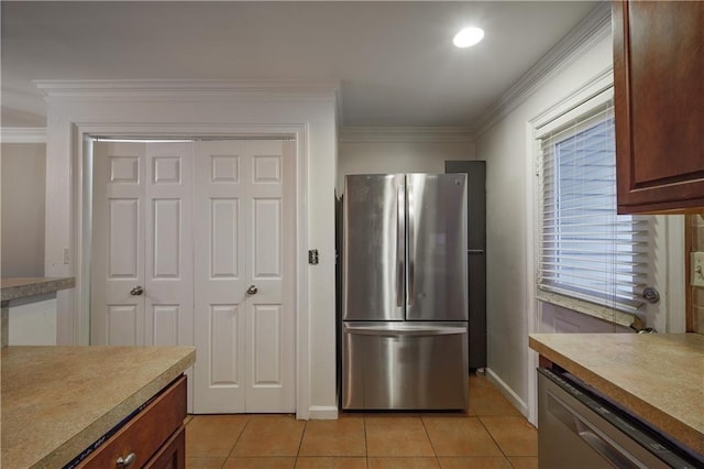 kitchen featuring light tile patterned floors, crown molding, stainless steel appliances, and light countertops