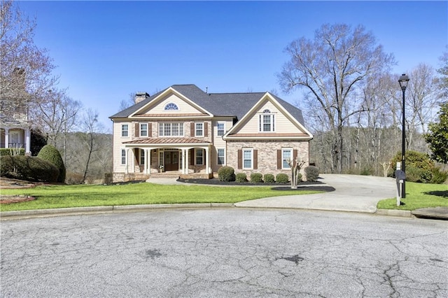 view of front of home featuring a porch, driveway, a chimney, and a front lawn