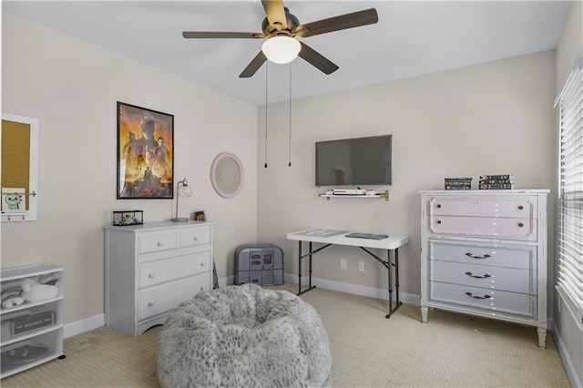 sitting room featuring light carpet, baseboards, and a ceiling fan