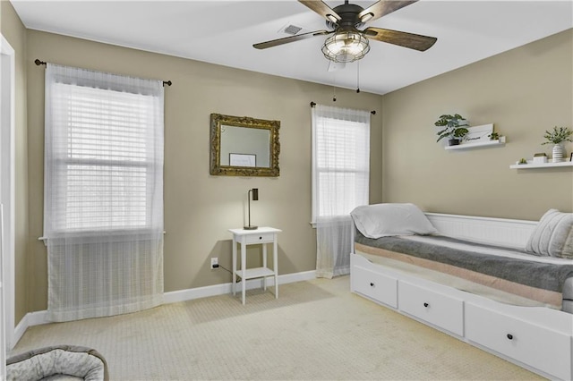 bedroom featuring light carpet, visible vents, multiple windows, and baseboards