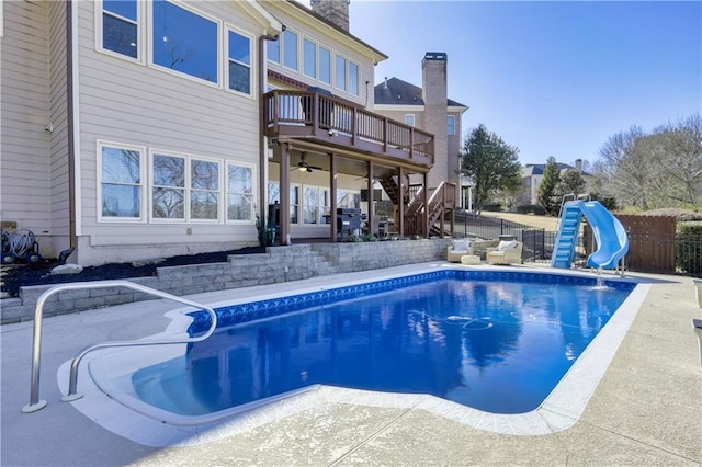 view of swimming pool featuring a fenced in pool, a water slide, stairway, fence private yard, and a patio area