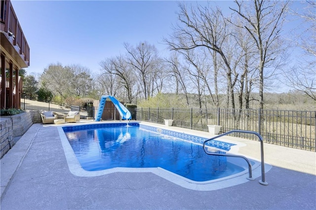 view of pool featuring a patio area, a fenced in pool, a water slide, and a fenced backyard