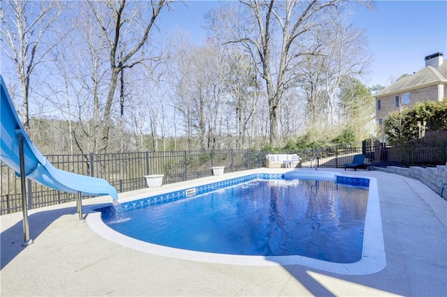 view of pool with fence, a fenced in pool, and a water slide