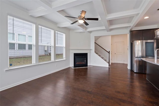 2231 Bedell Dr, Conyers, GA 30094 - unfurnished living room featuring beam ceiling, dark wood-type flooring, coffered ceiling, stairway, and a glass covered fireplace