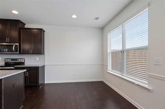 2231 Bedell Dr, Conyers, GA 30094 - kitchen featuring stainless steel appliances, dark wood-style flooring, dark brown cabinetry, recessed lighting, and light stone counters