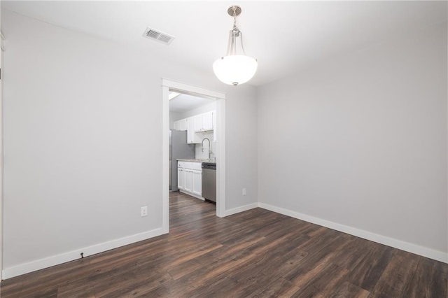 unfurnished room with dark hardwood / wood-style flooring and sink