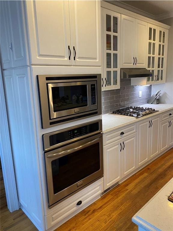 180 Hightower Lake Trl, Ball Ground, GA 30107 - kitchen with stainless steel appliances, light wood-type flooring, light countertops, and white cabinetry