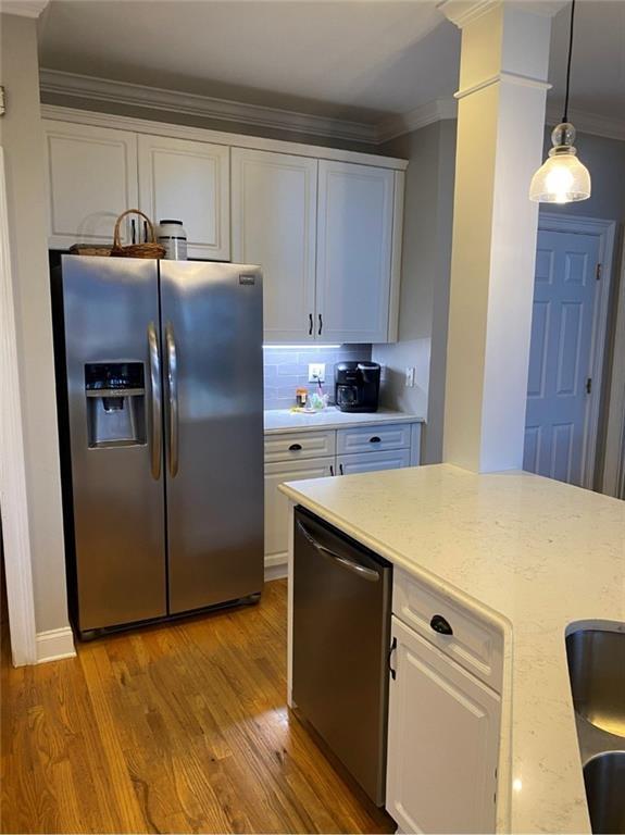 180 Hightower Lake Trl, Ball Ground, GA 30107 - kitchen with appliances with stainless steel finishes, crown molding, white cabinetry, light wood finished floors, and tasteful backsplash