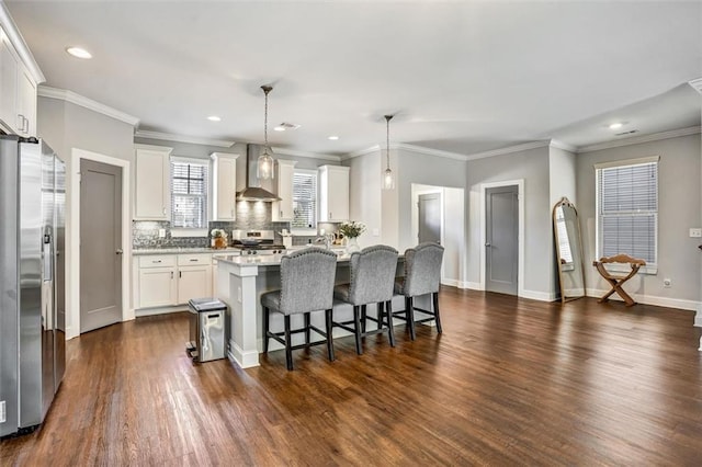 kitchen featuring decorative backsplash, dark wood-style floors, a kitchen breakfast bar, stainless steel appliances, and wall chimney range hood