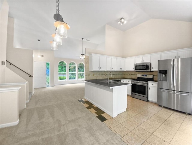 kitchen with backsplash, ceiling fan, appliances with stainless steel finishes, white cabinetry, and kitchen peninsula