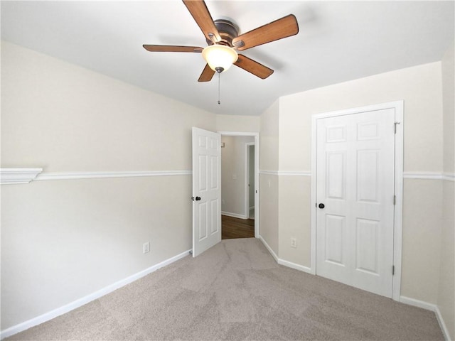 unfurnished bedroom with a closet, light colored carpet, and ceiling fan