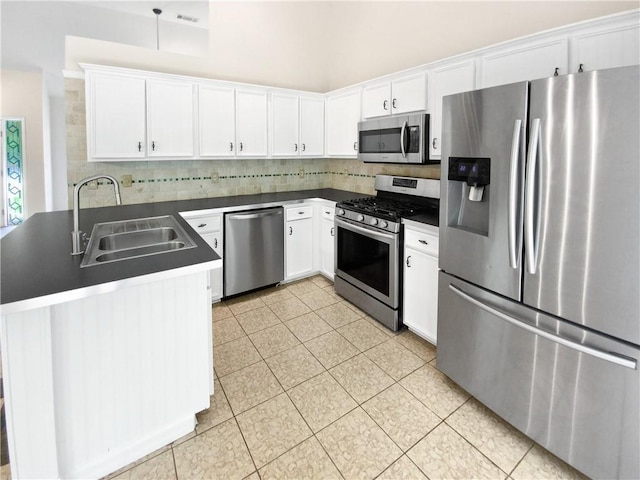 kitchen with decorative backsplash, appliances with stainless steel finishes, white cabinetry, and sink