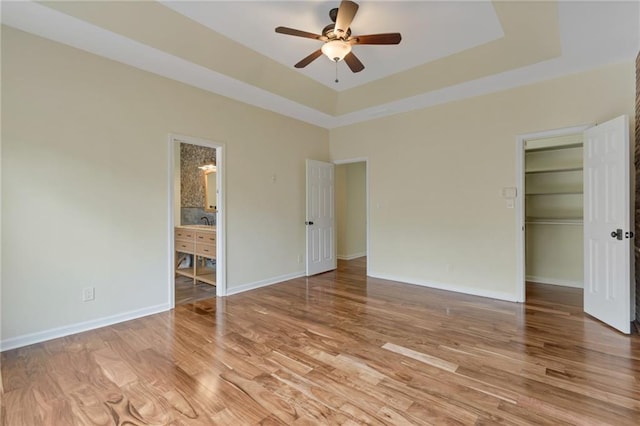 475 Brown Thrasher Ct, Alpharetta, GA 30009 - unfurnished bedroom with a tray ceiling, light wood finished floors, a spacious closet, a closet, and ensuite bathroom