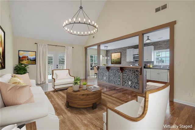 475 Brown Thrasher Ct, Alpharetta, GA 30009 - living area featuring wood finished floors, high vaulted ceiling, and a chandelier