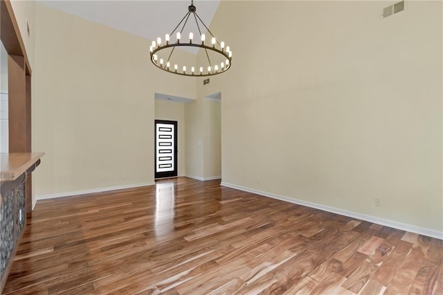 475 Brown Thrasher Ct, Alpharetta, GA 30009 - unfurnished dining area featuring a high ceiling, wood finished floors, and a chandelier