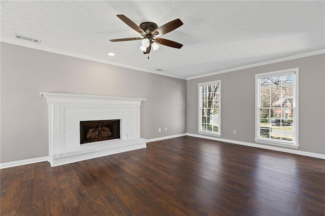 unfurnished living room with baseboards, visible vents, dark wood finished floors, a textured ceiling, and a brick fireplace