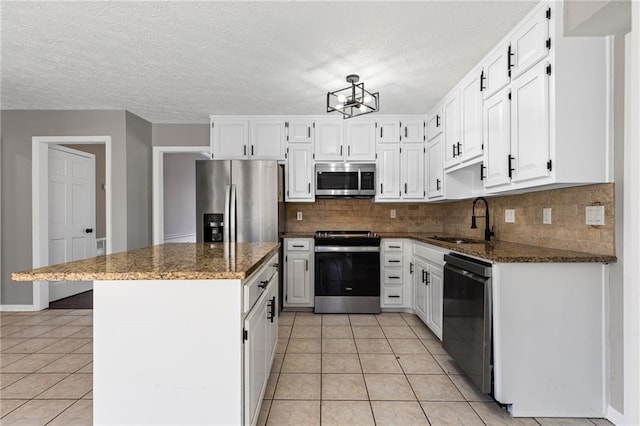 kitchen with light tile patterned floors, white cabinets, appliances with stainless steel finishes, and a sink