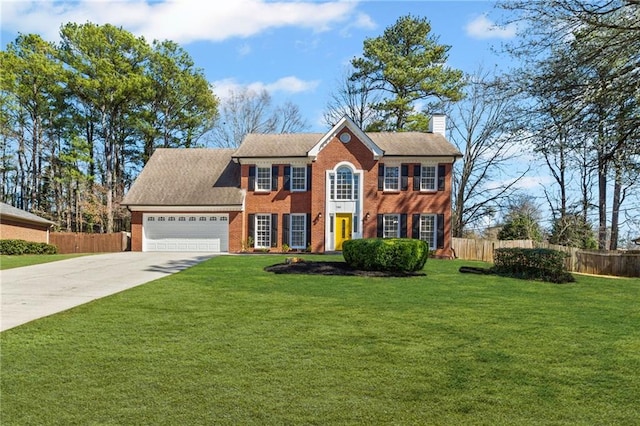 colonial house featuring brick siding, an attached garage, fence, a chimney, and driveway