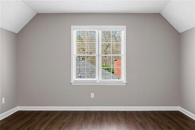 additional living space with a wealth of natural light, baseboards, and dark wood-style flooring